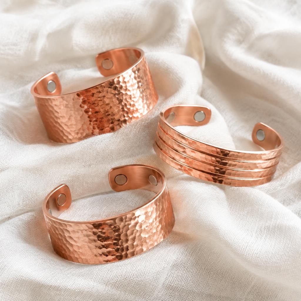 Polished and hammered copper bracelets on pale linen